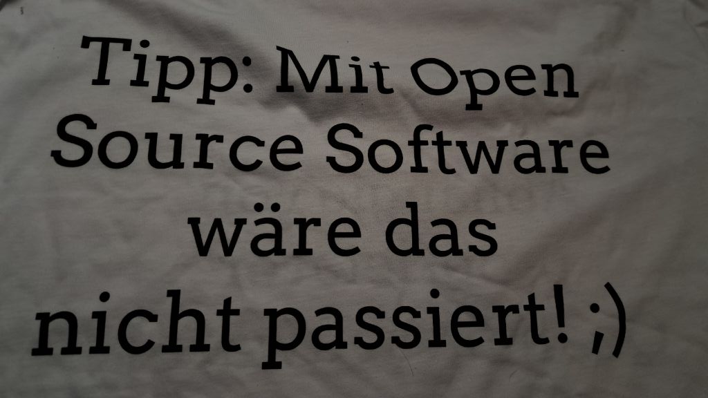 Rückseite T-Shirt mit &ldquo;Tipp: Mit Open Source Software wäre dies nicht passiert! ;)&rdquo;